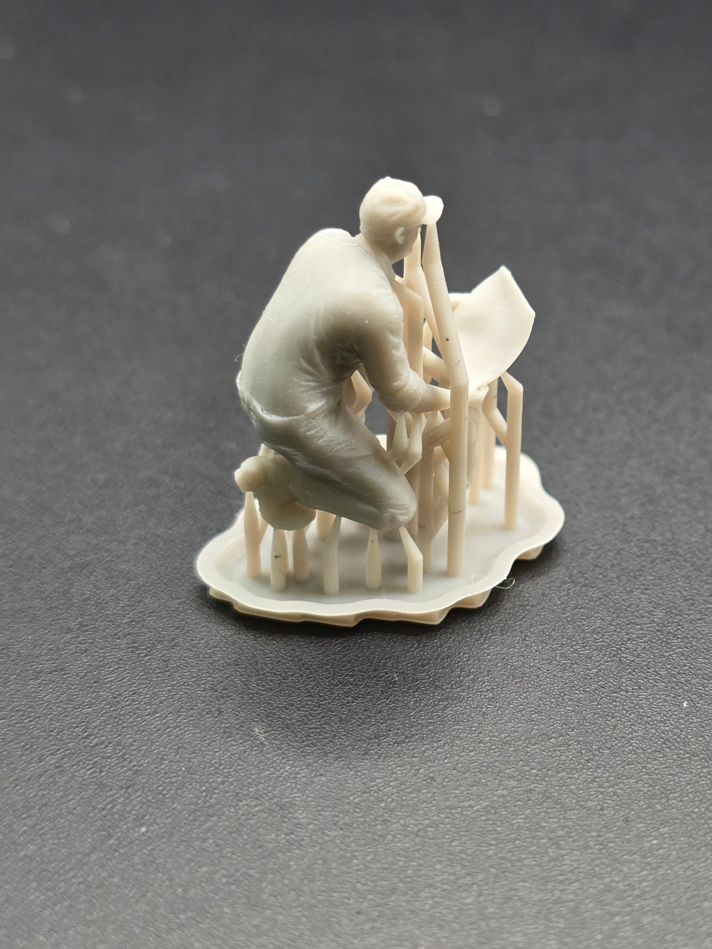 Arbeiter auf einem Knie mit einem Plan in der Hand im Maßstab 1/50