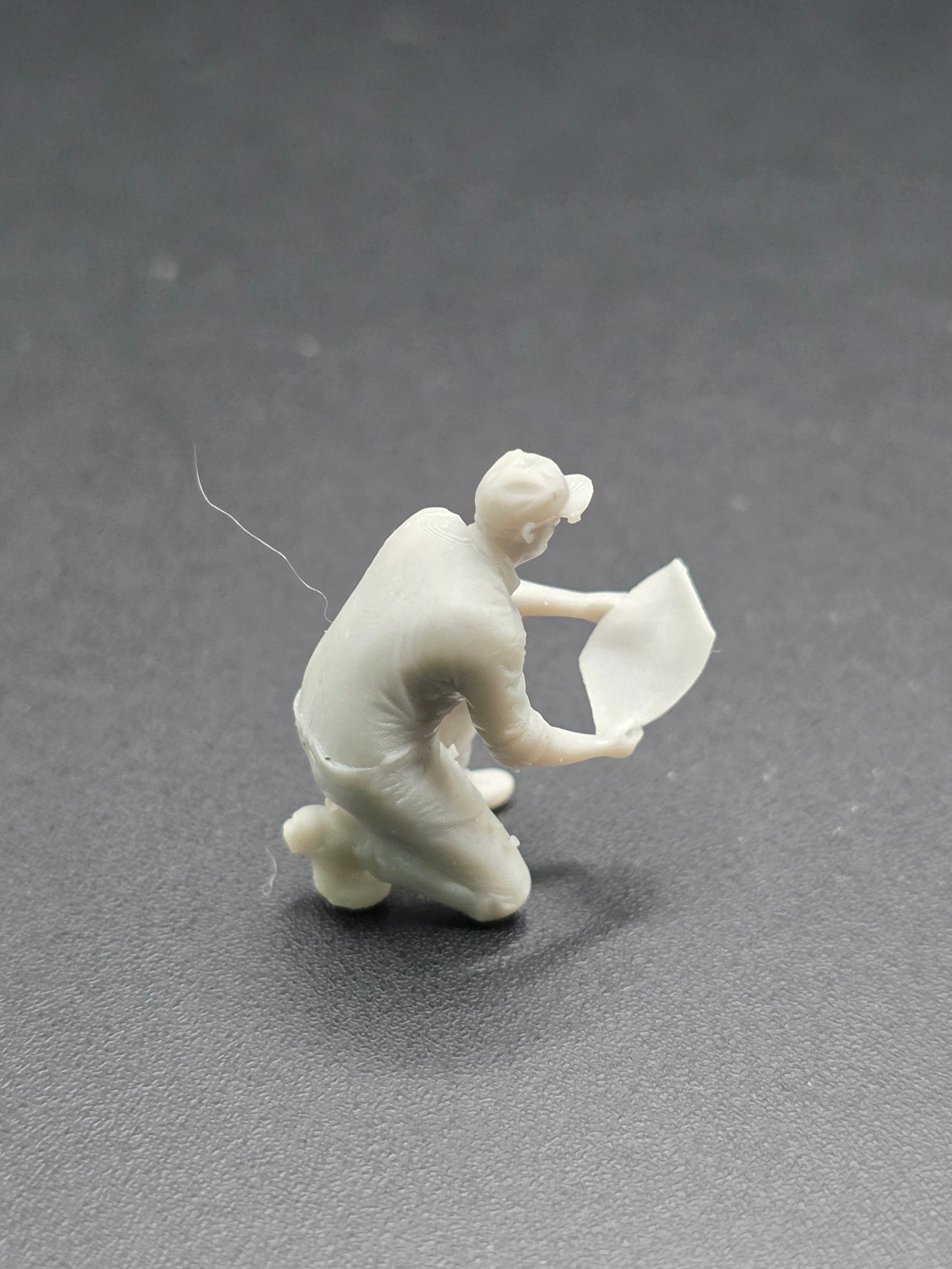 Arbeiter auf einem Knie mit einem Plan in der Hand im Maßstab 1/50